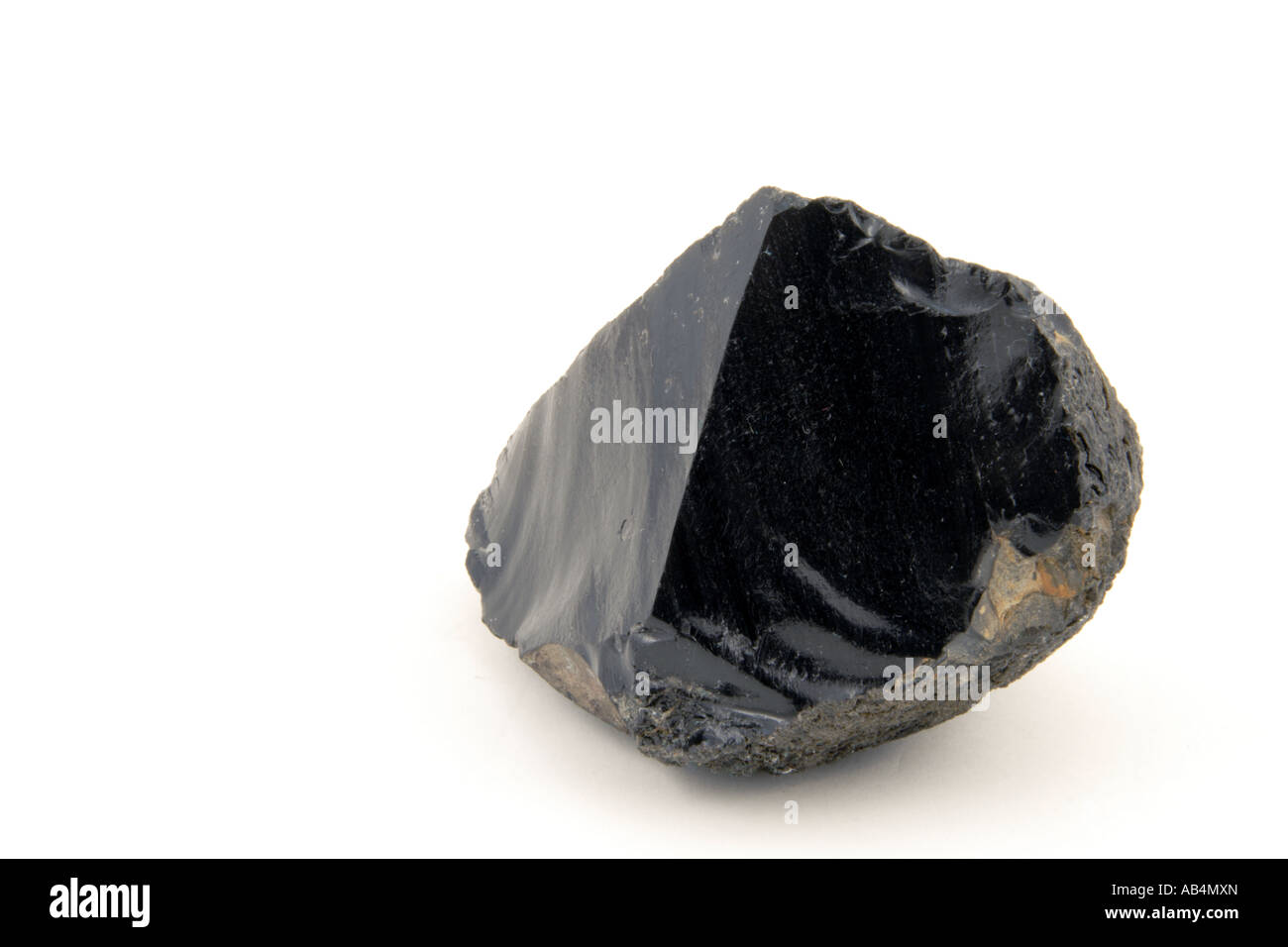 Ein Stück schwarzem Obsidian (vulkanisches Glas) mit einem glasigen Konchoidalbruch auf weißem Hintergrund, Sardinien, Italien. Stockfoto
