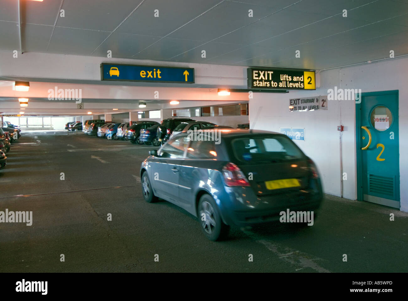 Innenansicht des besetzten PKW-Stellplätze im Stadtzentrum Parkhaus mit Autofahrer fahren entlang in Richtung Ausgang Stockfoto