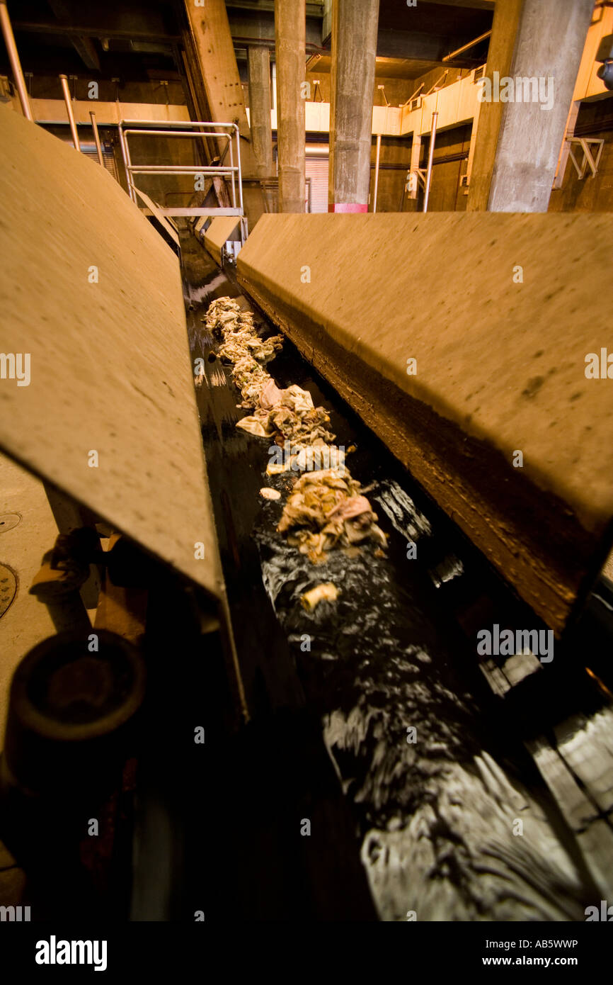 Große und nichtökologischen Materialien angespannt aus Abwasser fließen hinunter einen Kanal auf einer Kläranlage. Stockfoto
