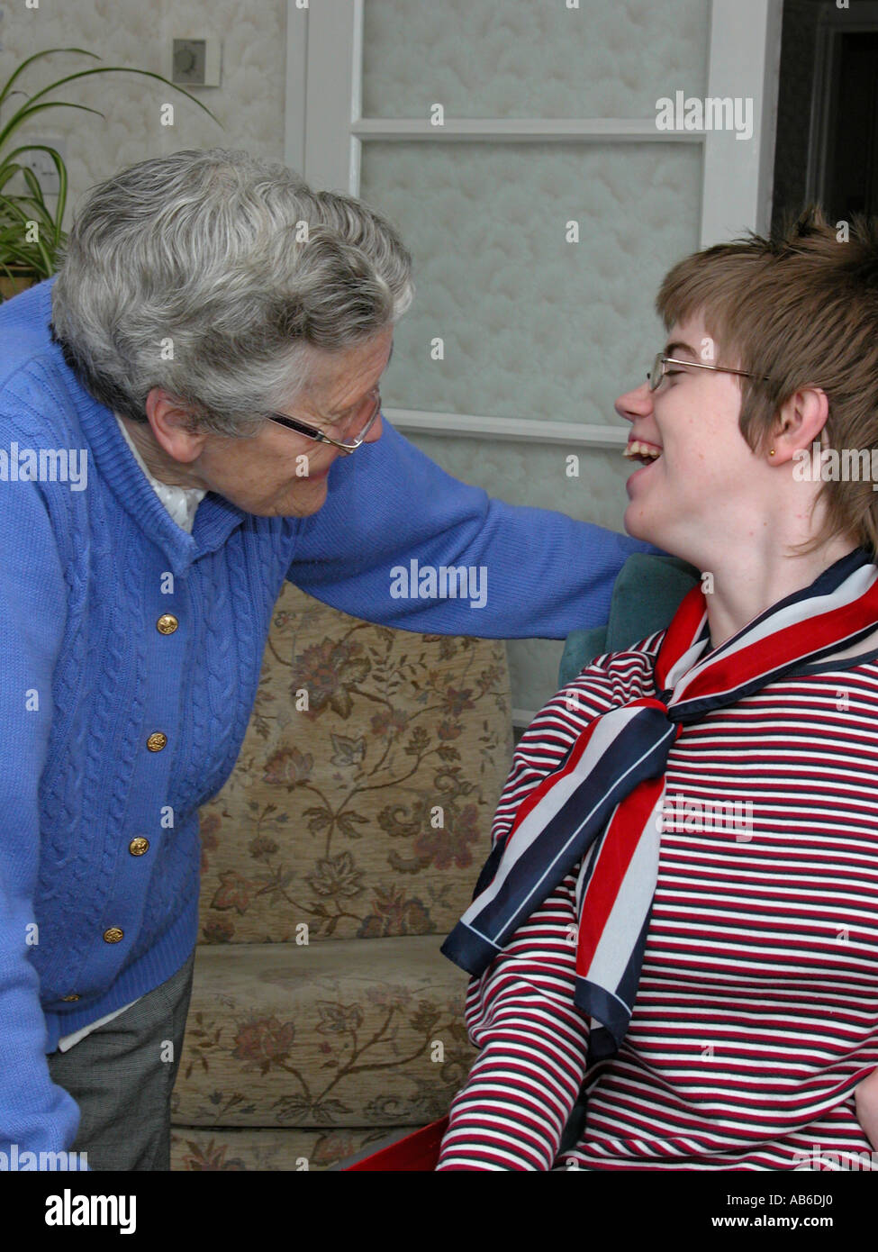 18 Jahre alte Teenager-Mädchen mit zerebraler Lähmung einen lachen mit einer älteren Frau zu teilen könnten relative Pflegeperson Freund Nachbar sein. Stockfoto