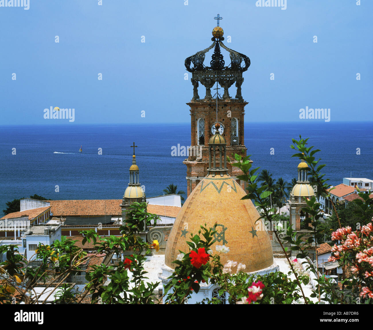 Turm von Guadalupe Church Glocke mit Blumen und Parasailor über Pazifischer Ozean in Puerto Vallarta Mexiko Stockfoto