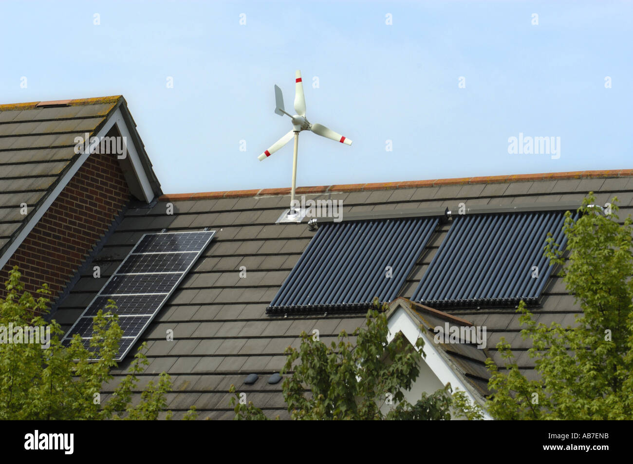 Mikro Wind Turbine Solar Photovoltaik und Evacuated Solarröhren am Dach des Hauses in Ferndown Dorset-England Stockfoto