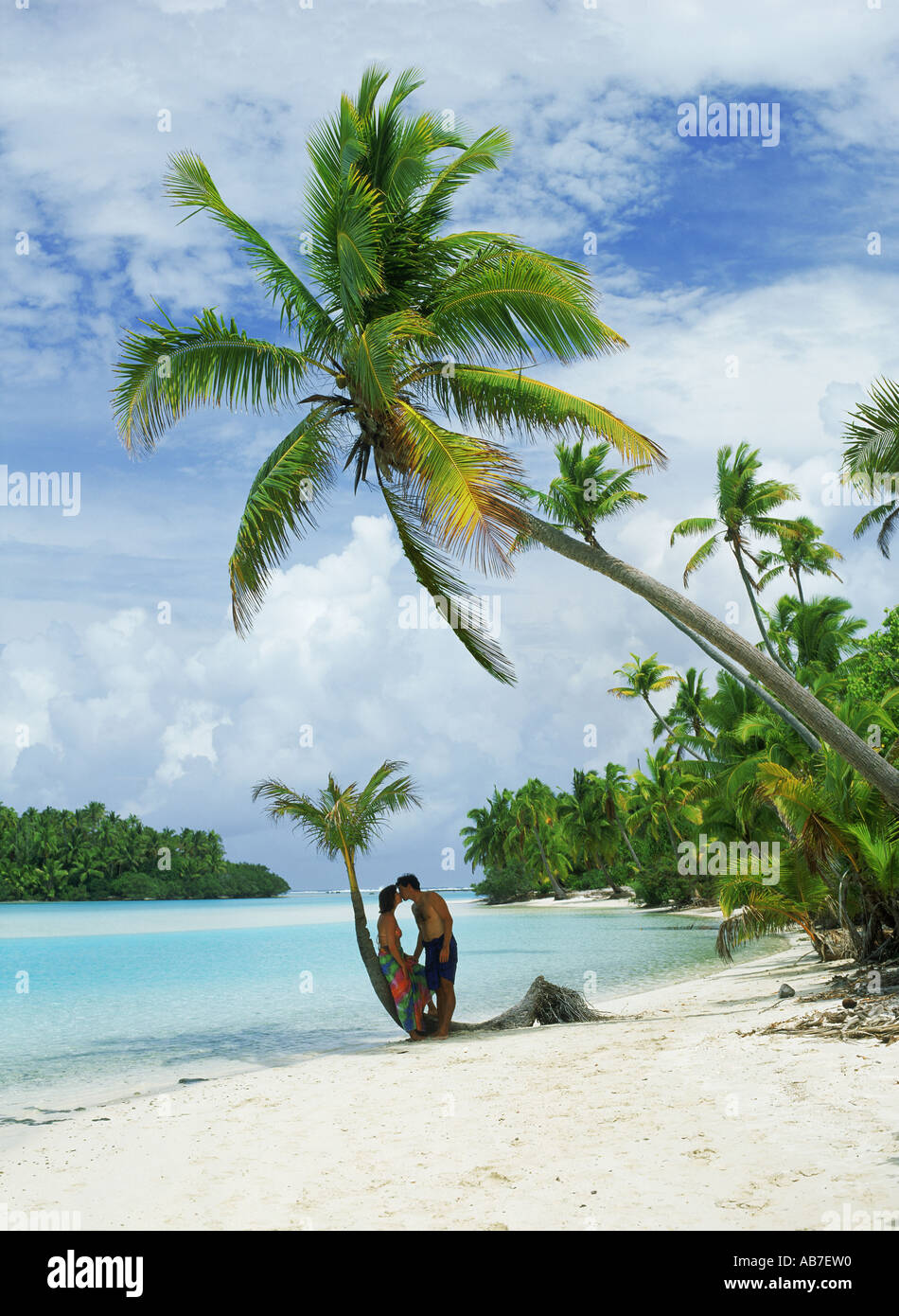 Paar küssen unter Palmen auf One Foot Island in Insel Aitutaki Lagune, Cook-Inseln Archipel gehörende Stockfoto