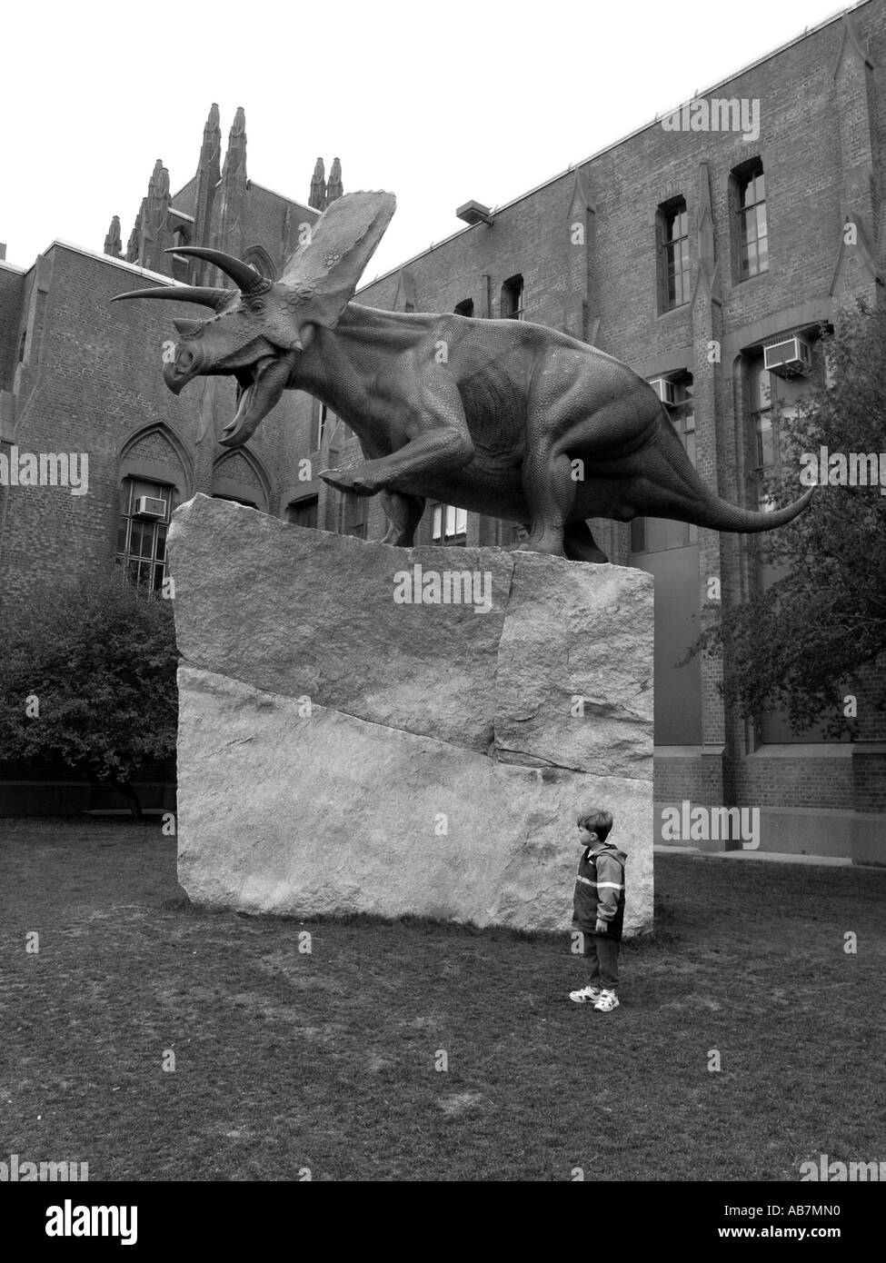 Kind steht neben massiven Dinosaurier Skulptur vor dem Yale Peabody museum Stockfoto