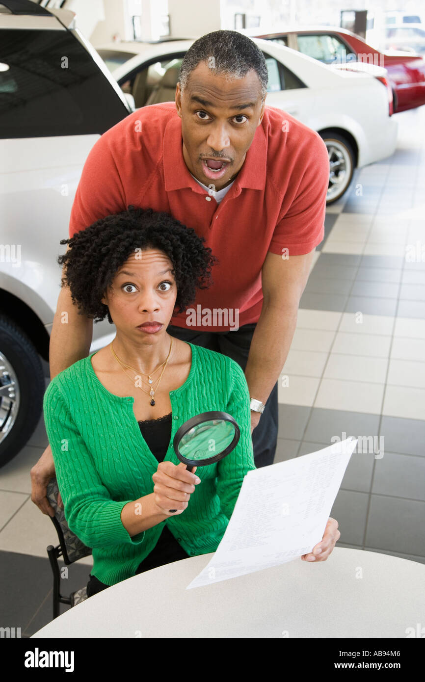 Frau liest das Kleingedruckte mit einer Lupe Stockfoto