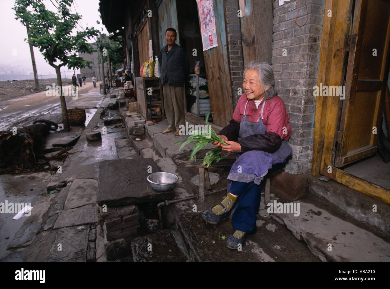 Eine ältere Frau sitzt vor ihrem Haus auf den Straßen des alten Fengdu China, für das 3-Schluchten-Staudamm-Projekt 041803 dem Erdboden gleichgemacht Stockfoto