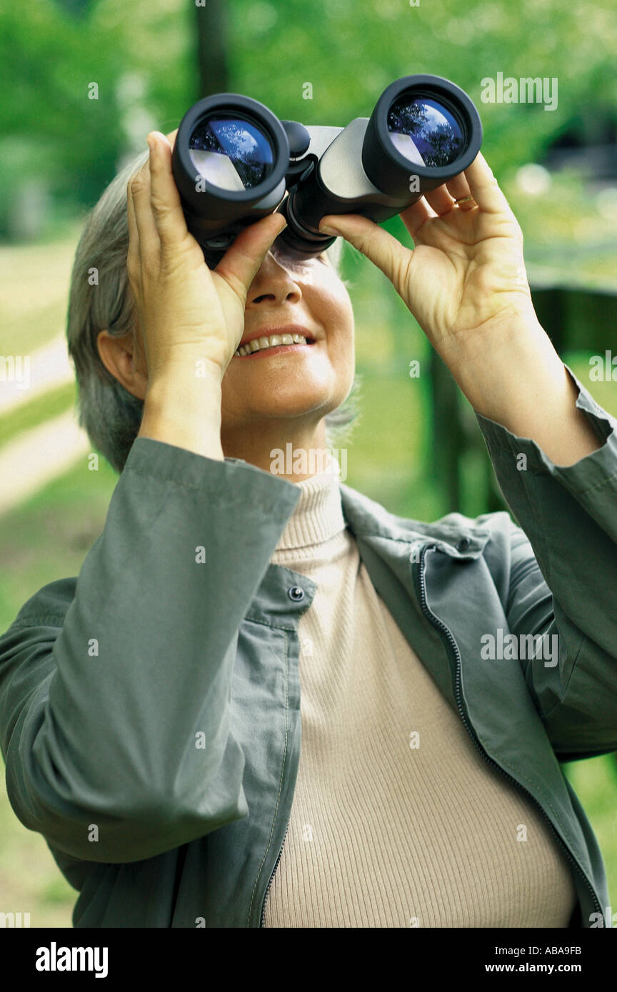 Frau, die durch ein Fernglas Stockfoto