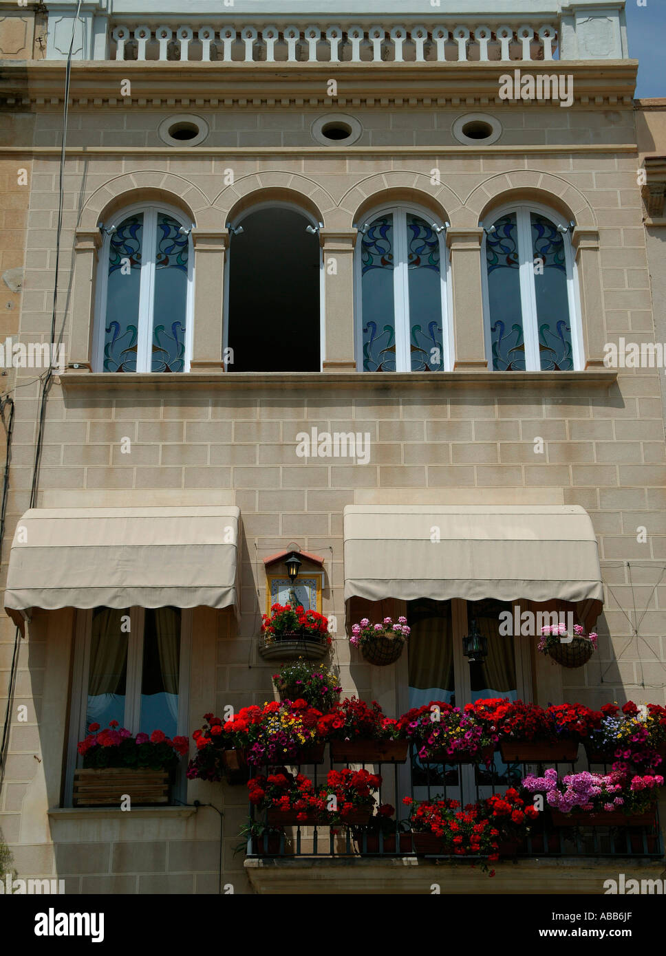 Wohnungen mit Balkon mit farbenfrohen Blumen und Bogenfenstern, Sitges Costa Dorada-Katalonien-Spanien-Europa Stockfoto