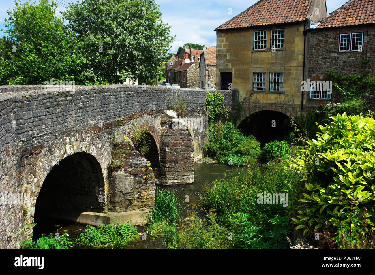 Alte steinerne Brücke und Häuser über Fluss kauen Pensford Avon Somerset Stockfoto
