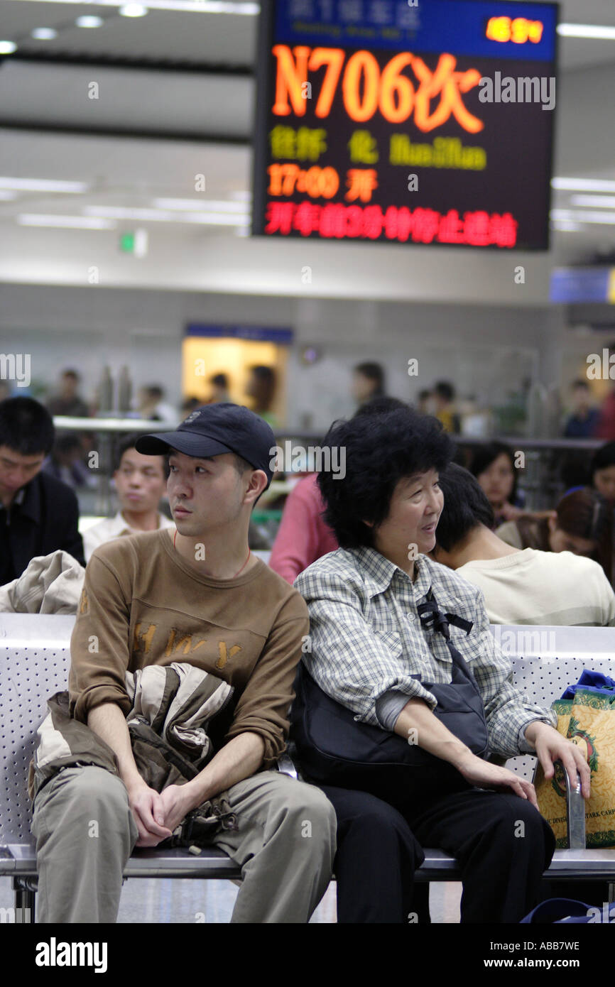 Mutter und Erwachsene Sohn warten auf ihren Zug zu Huaihua im Bahnhof Shenzhen, Shenzhen, China Stockfoto