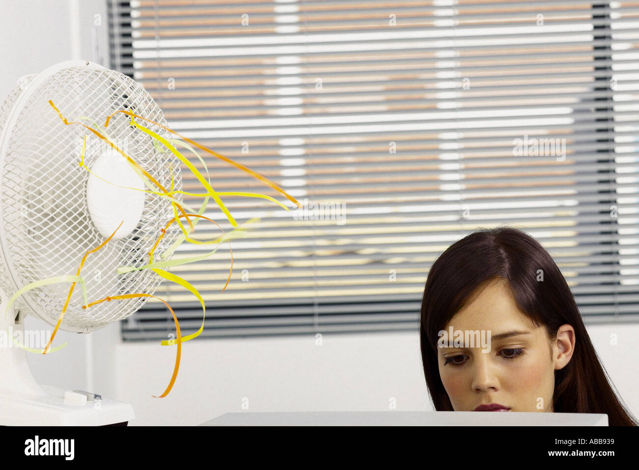 Geschäftsfrau, die Kühlung durch Ventilator im Büro Stockfoto