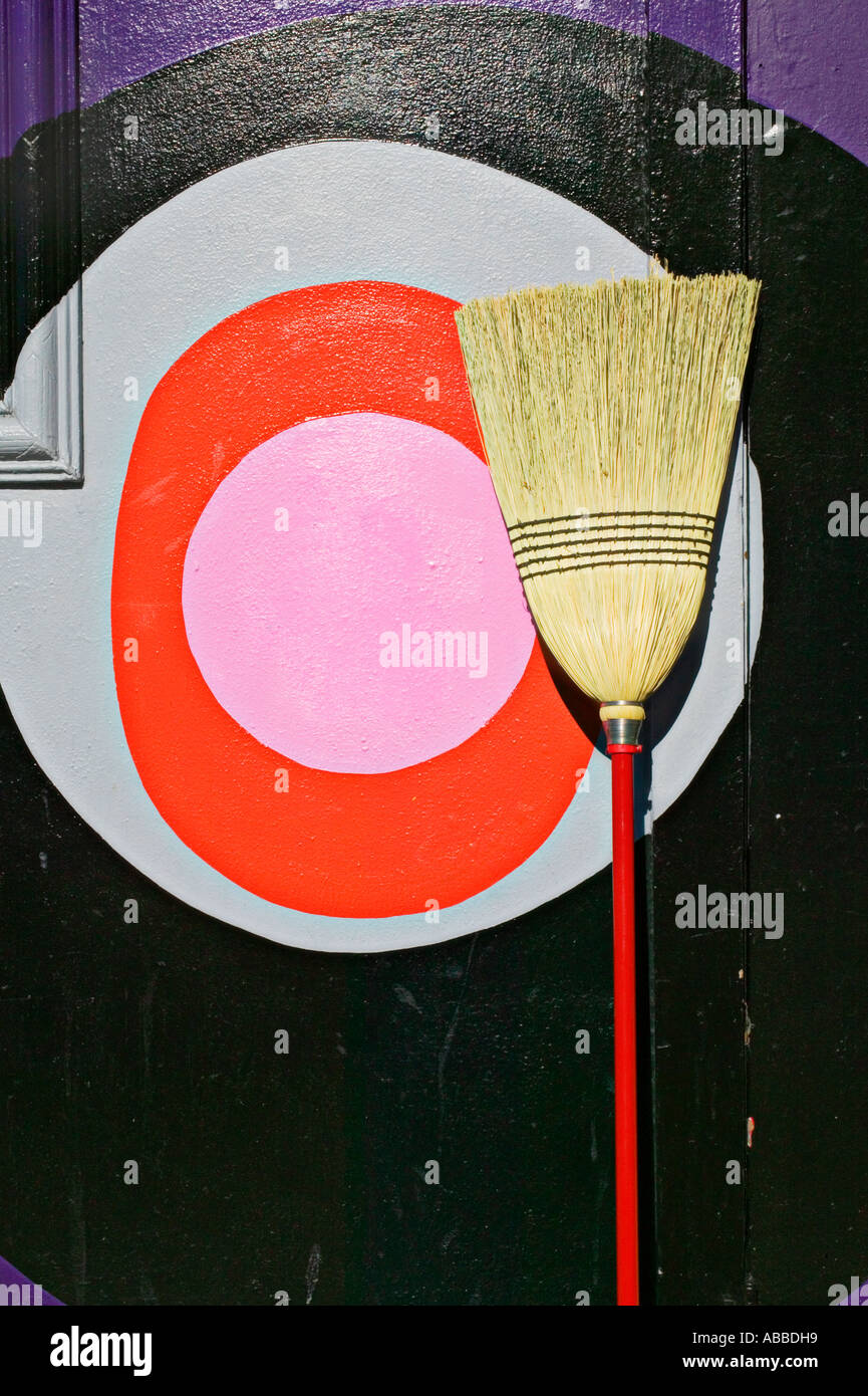 Besen Sie mit rosa Kreis in Ruhe an Wand Stockfoto