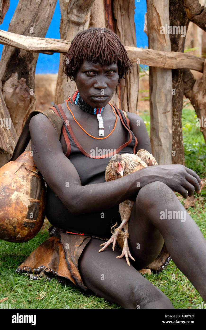 Alte Frau mit einer Kalebasse hält ein Huhn auf dem Markt der Keyafer Äthiopien Stockfoto
