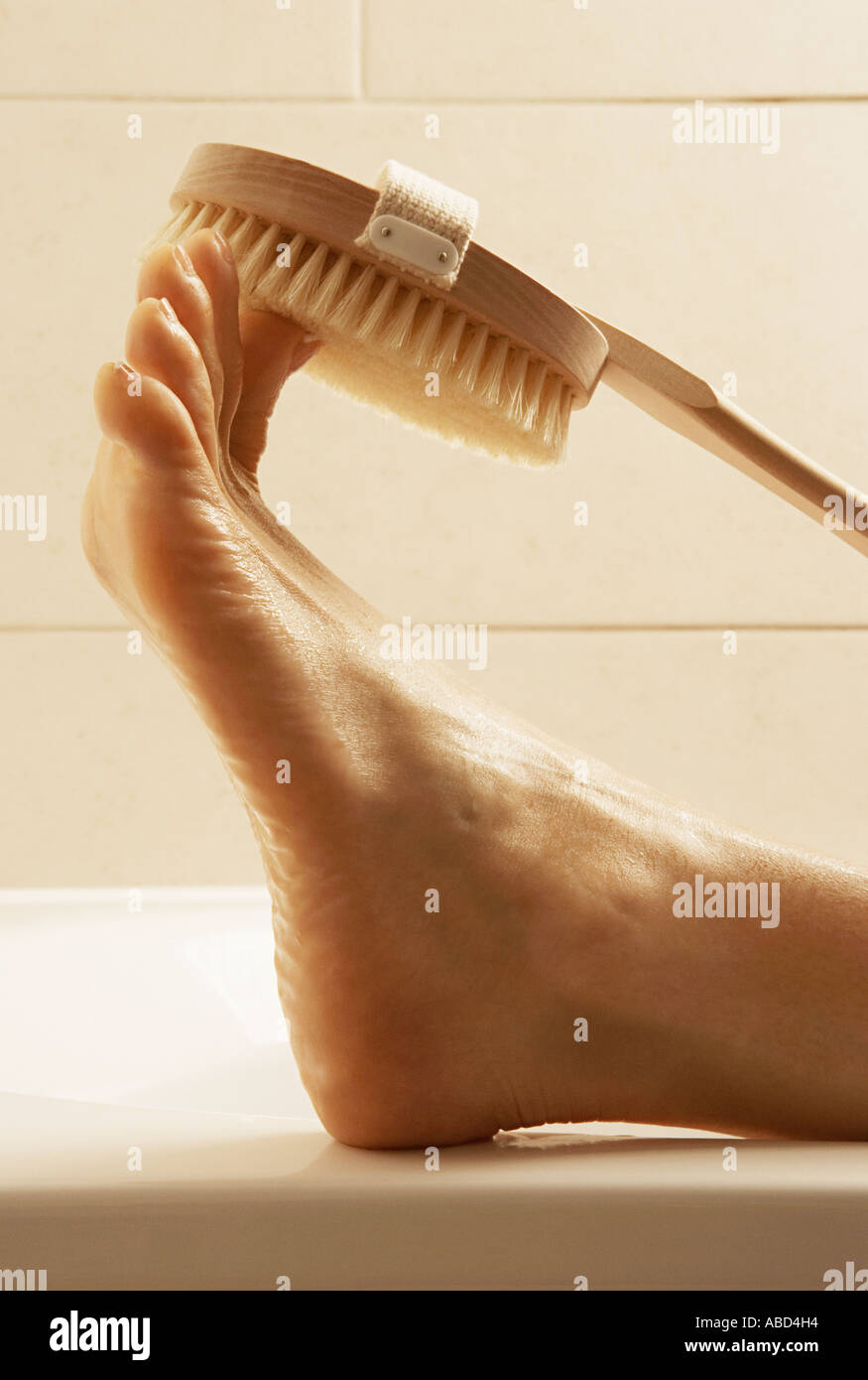 Frau schrubben ihre Zehen Stockfoto