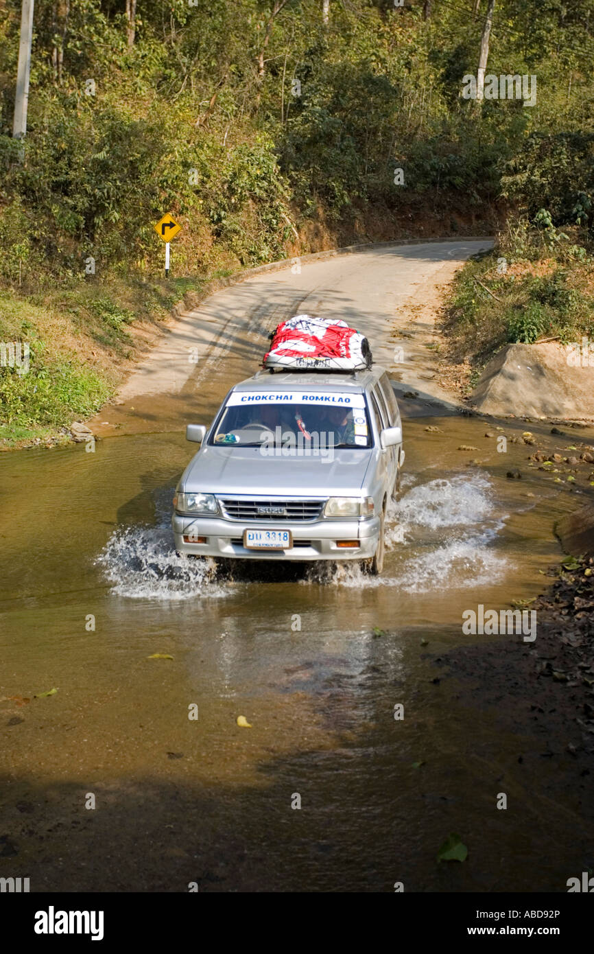 Mit dem Geländewagen fahren Fahrzeugantriebe durch Ford auf schmalen Straße in der Nähe von Mae Hong Son Nord Thailand Stockfoto