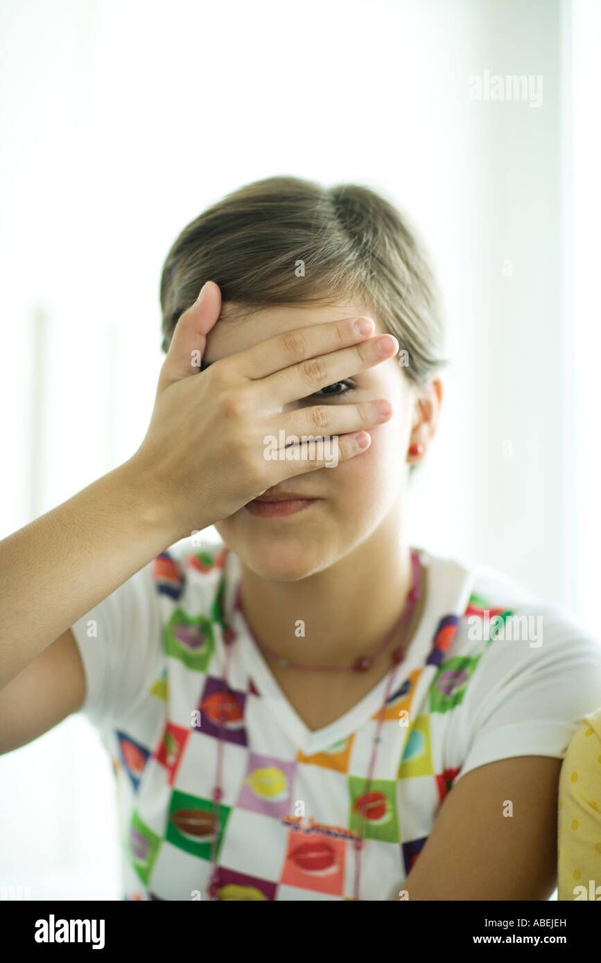 Teengirl für Gesicht mit Hand, spähen durch Finger Stockfoto