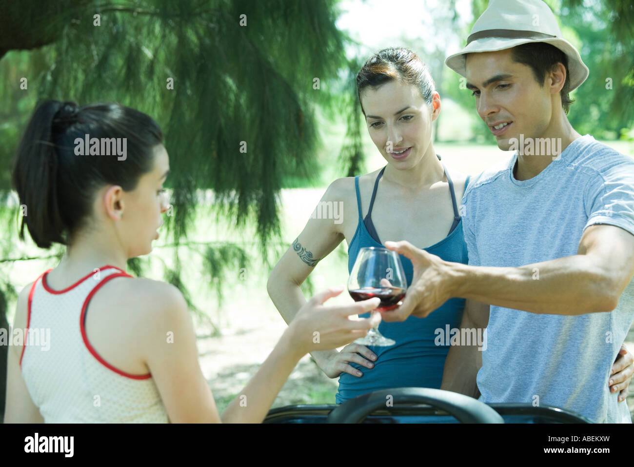 Man übergibt Teengirl Glas Wein während der Grillparty Stockfoto