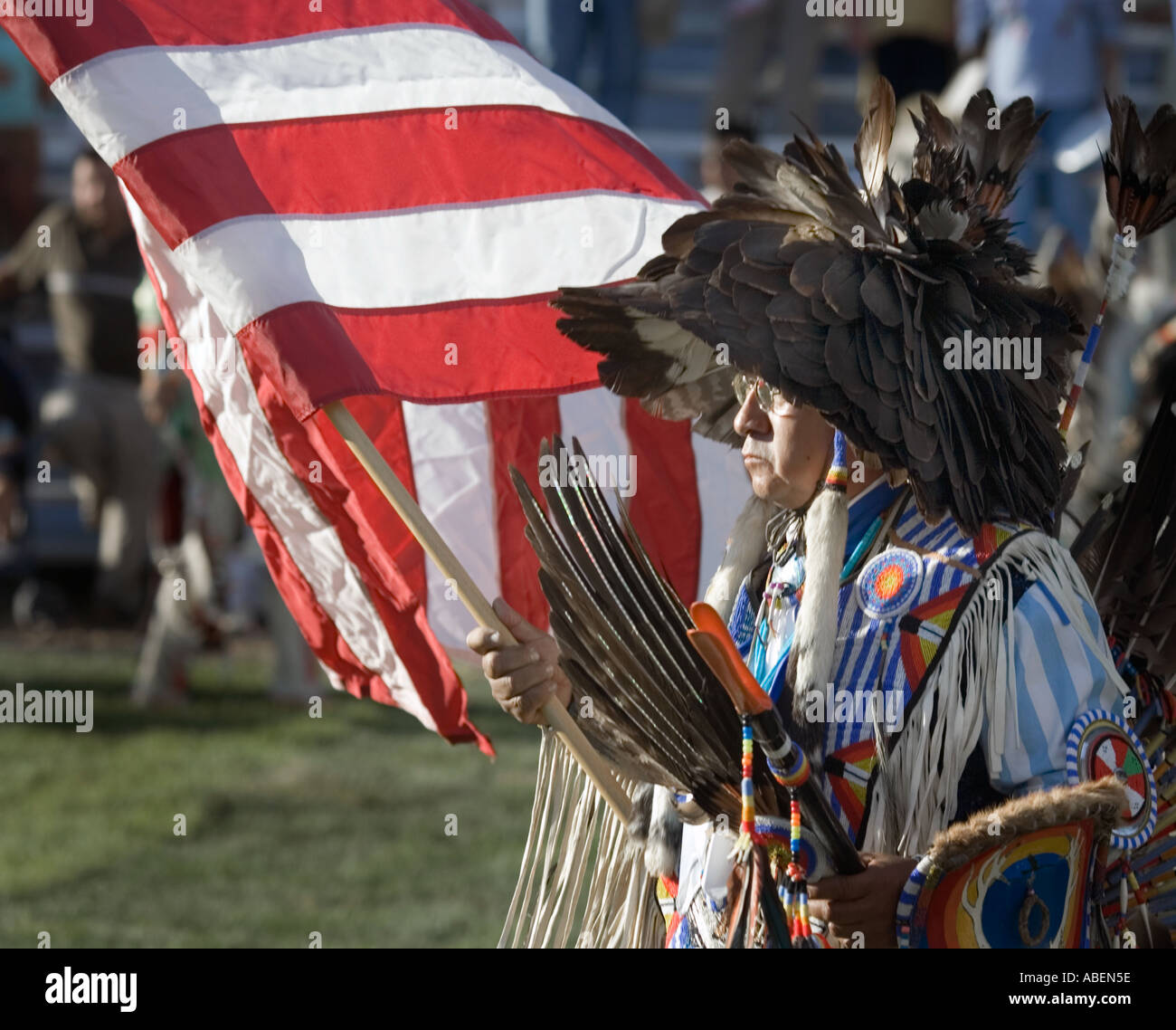 Ein Indianer in voller Montur bei einem Powwow im Norden Utahs mit Flagge der Vereinigten Staaten während der Eröffnungsfeier Stockfoto