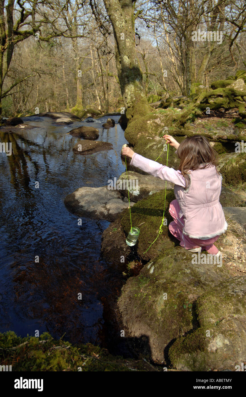 Kind Angeln mit einem Glas und Zeichenfolge in einen Stream, Dartmoor, Devon, England, UK Stockfoto