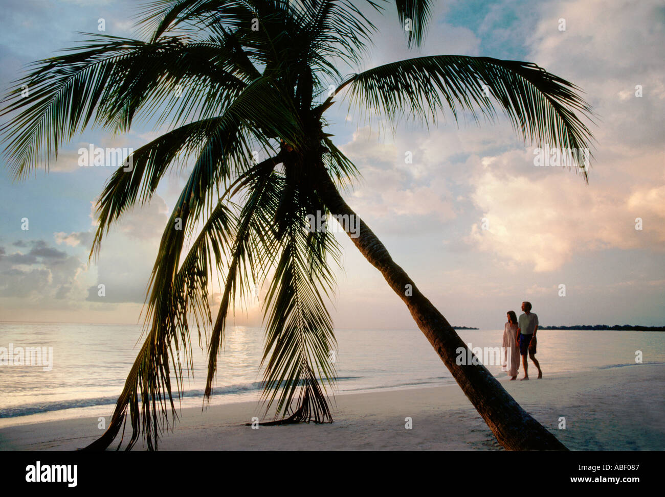 Paare, die auf Long Beach Negril Jamaika WI bei Sonnenuntergang Stockfoto