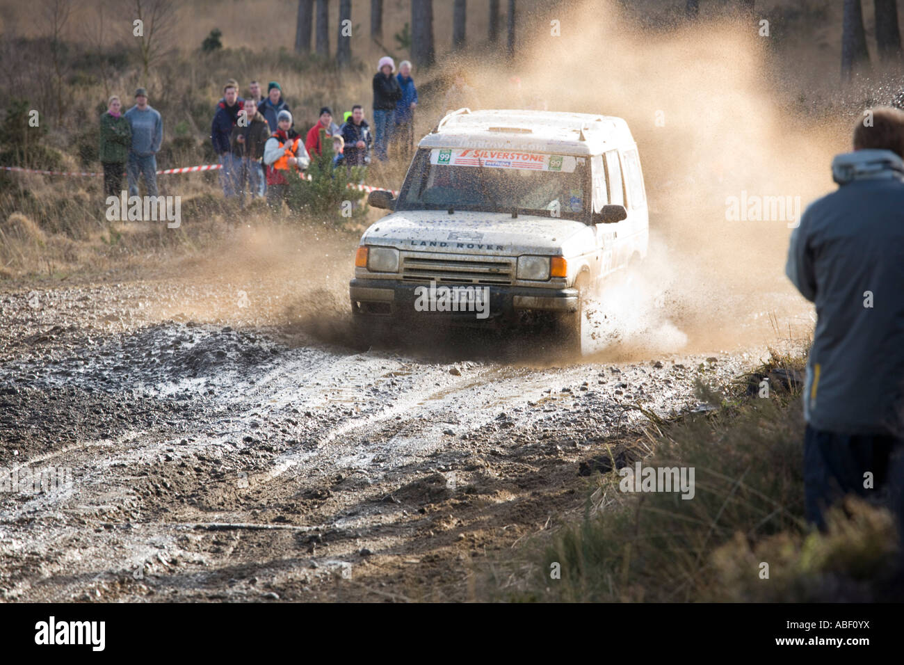 Land Rover Discovery Rallye-Auto spritzt durch Pfütze fahren auf Schlamm und Kies Stockfoto