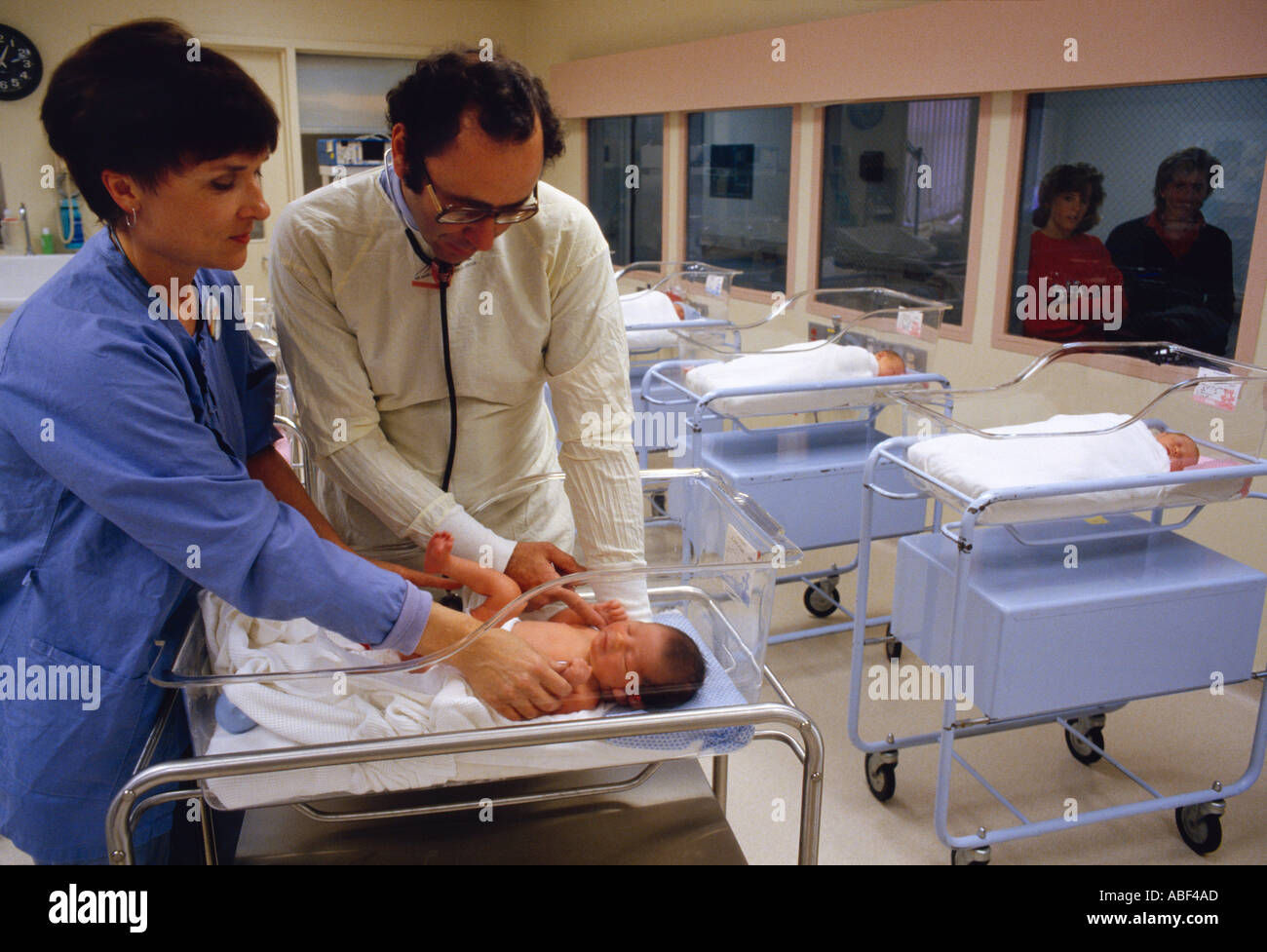 Medical - ein Kinderarzt und Krankenschwester untersuchen ein neugeborenes Kind in einem Krankenhaus Kindergarten / USA. Stockfoto