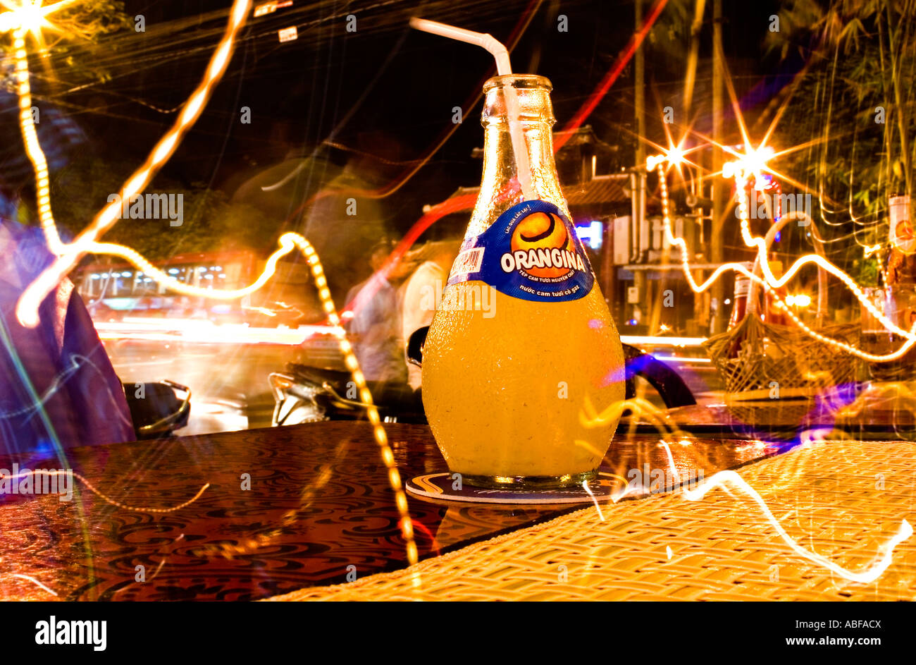 Orangina Flasche am Tisch in Vietnam Saigon Cafe in der Nacht Stockfoto