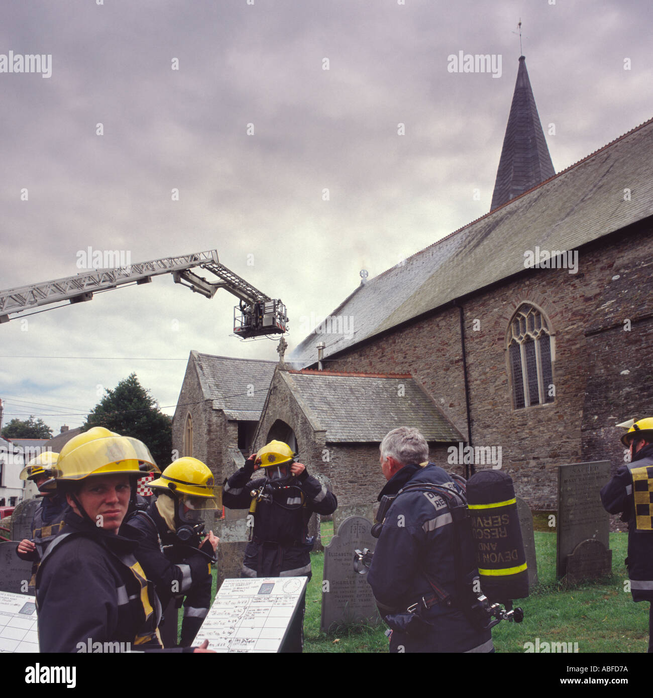 Gruppe von Feuerwehrleuten bekämpfen Dach Brandgefahr durch Kleinkinder an der St. Brannocks Kirche Braunton North Devon in England Stockfoto