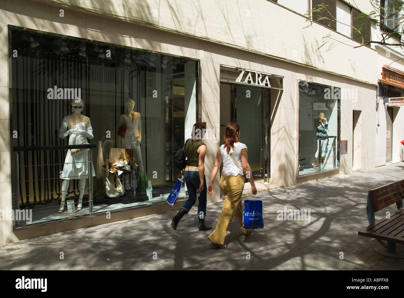 dh Calle de Leon Y Castillo ARRECIFE LANZAROTE zwei junge Damen mit Einkaufen zu Fuß vorbei Zara Bekleidungsgeschäft Mode Mädchen spanien Stoff Geschäft Frauen Stockfoto