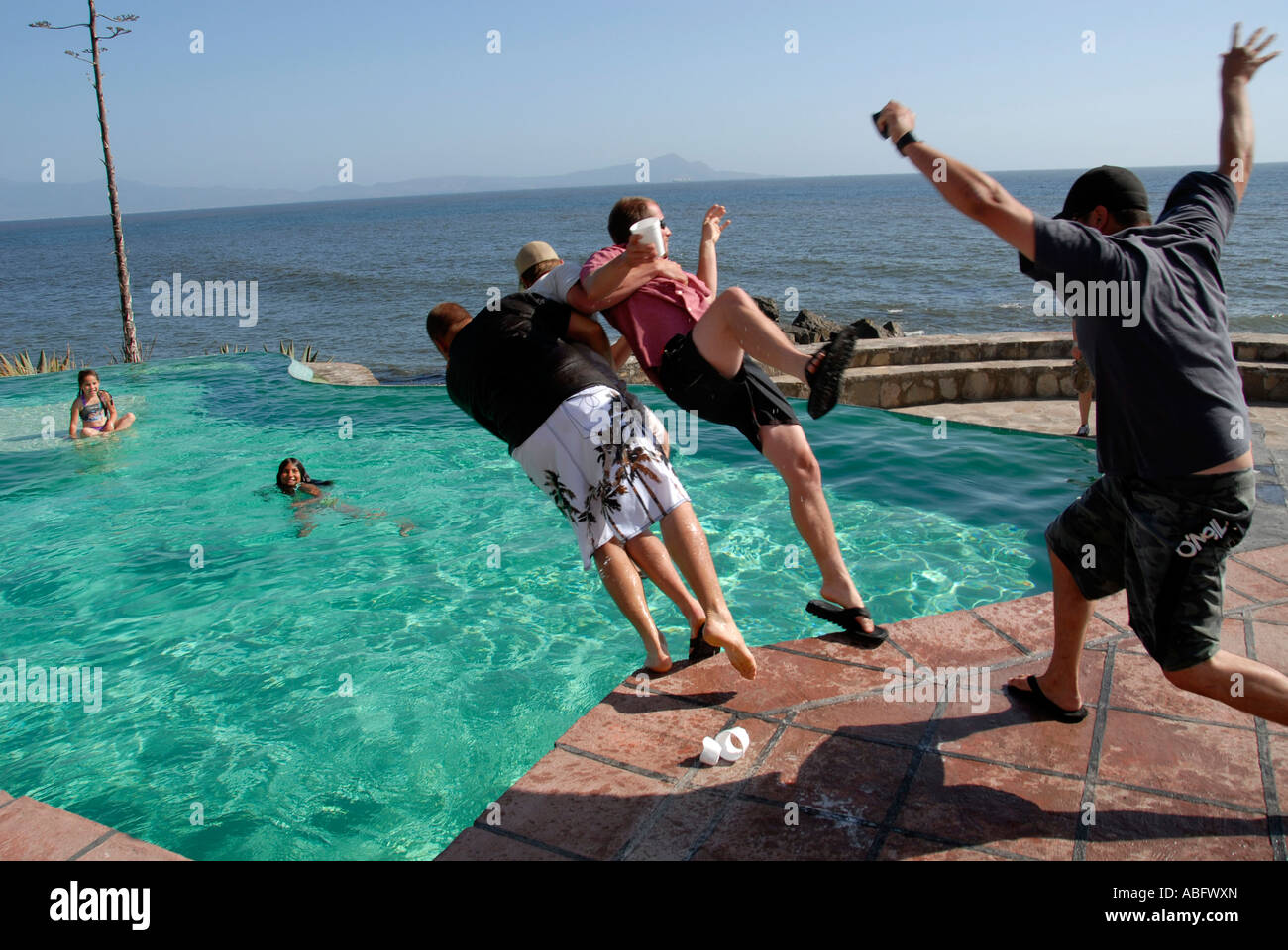 Junge Männer Ringen und einander in ein Becken zu ziehen. Stockfoto