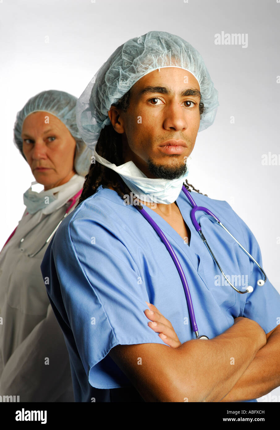Männliche und weibliche Ärzte mit Maske Haarnetz Handschuhe, Peelings und Stethoskop auf weißem Hintergrund Stockfoto