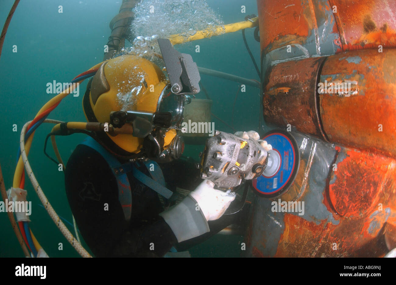 US Navy Diver verwendet eine Schleifmaschine, unten ein Reparatur-Patch auf dem versunkenen Bug der USS Ogden einzureichen. Stockfoto