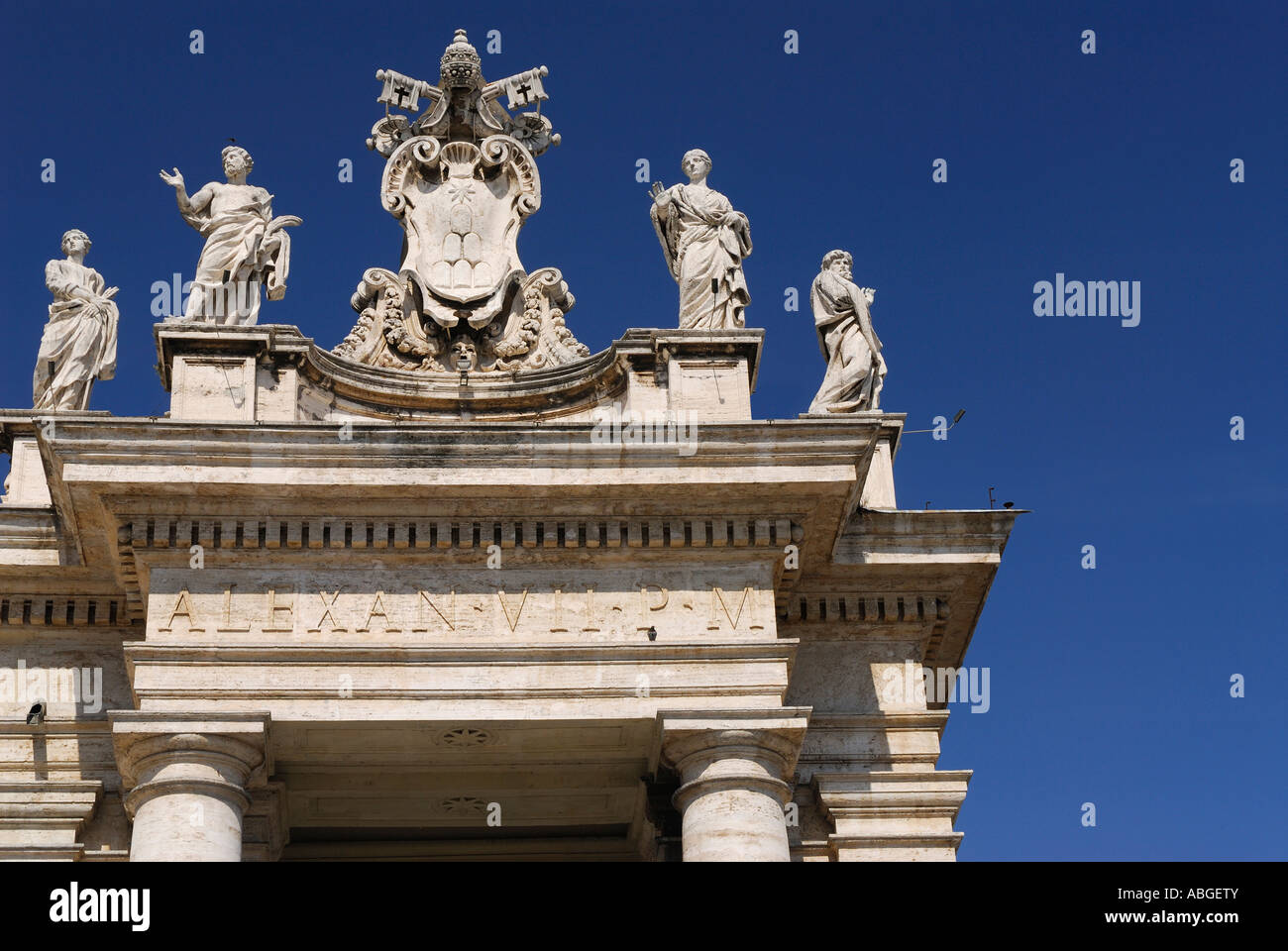 Detail der Statuen und Vatikan Wappen auf päpstliche Basilika St Peters Piazza Kolonnaden Rom Italien mit blauem Himmel Stockfoto