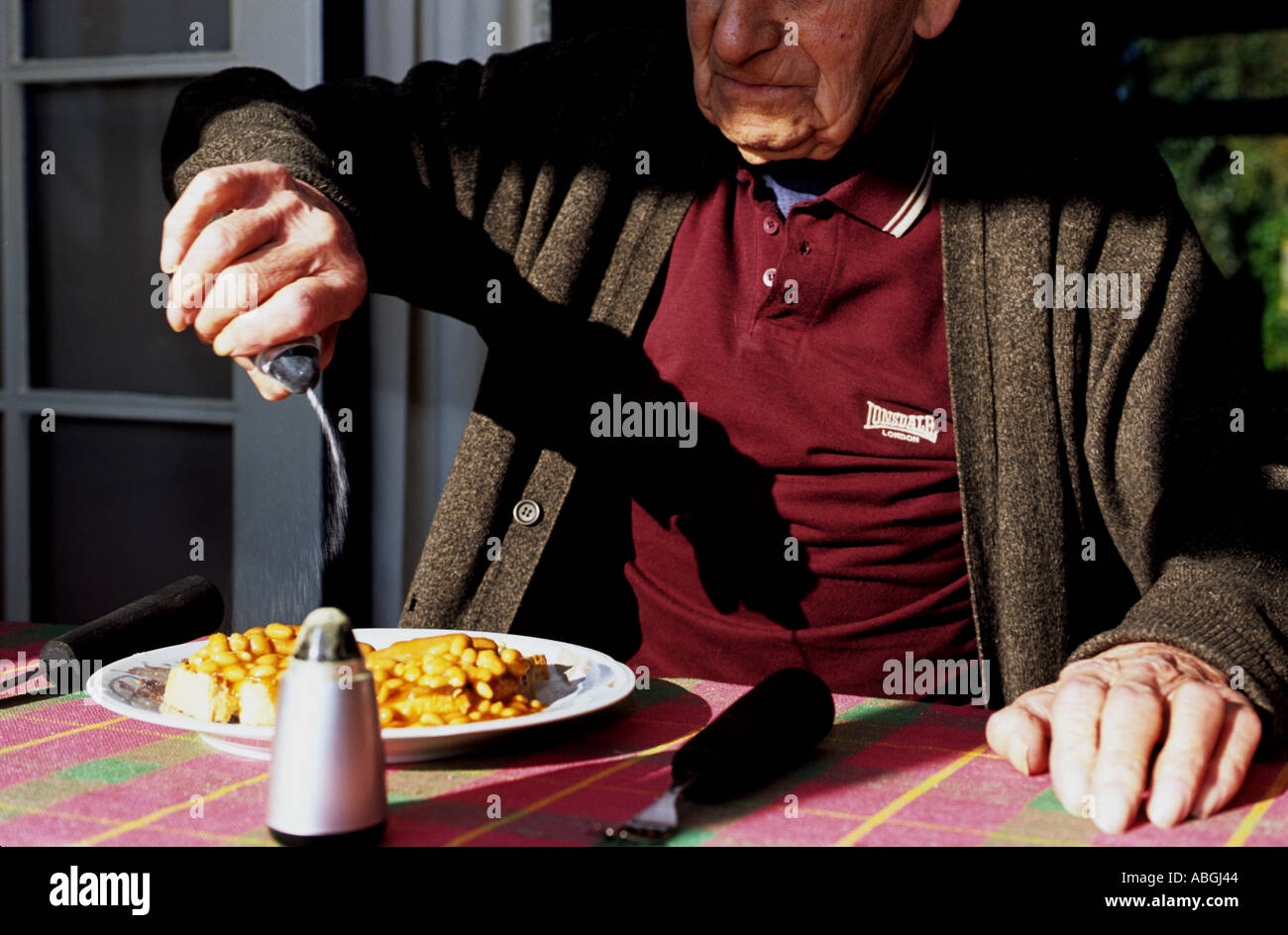 Alte im Alter Rentner, die Zugabe von Salz, Bohnen auf toast  Stockfotografie - Alamy