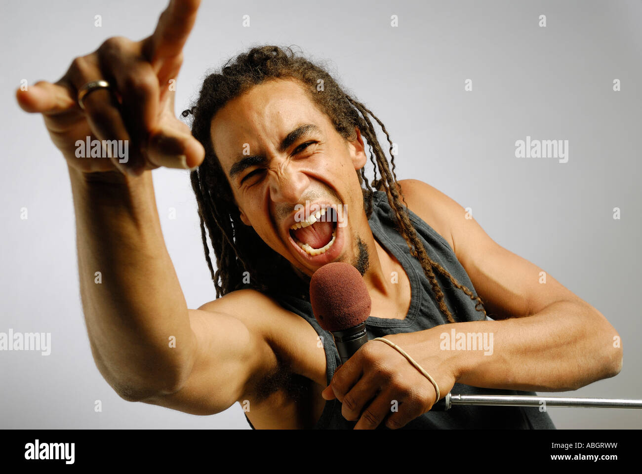 Schwarzer Mann mit Hand gestikulieren und schreien in ein Mikrofon auf Kunden-Hintergrund Stockfoto