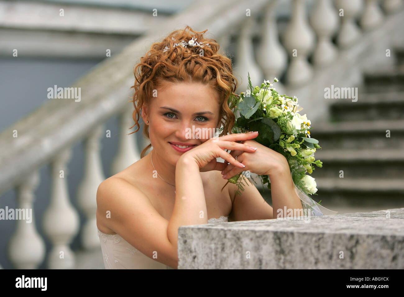 Ein Porträt einer Braut in eine traditionelle weiße Hochzeit Kleid an ihrem Hochzeitstag abgebildet. Sie ist in einen halben Körper Porträt Hol Stand. Stockfoto