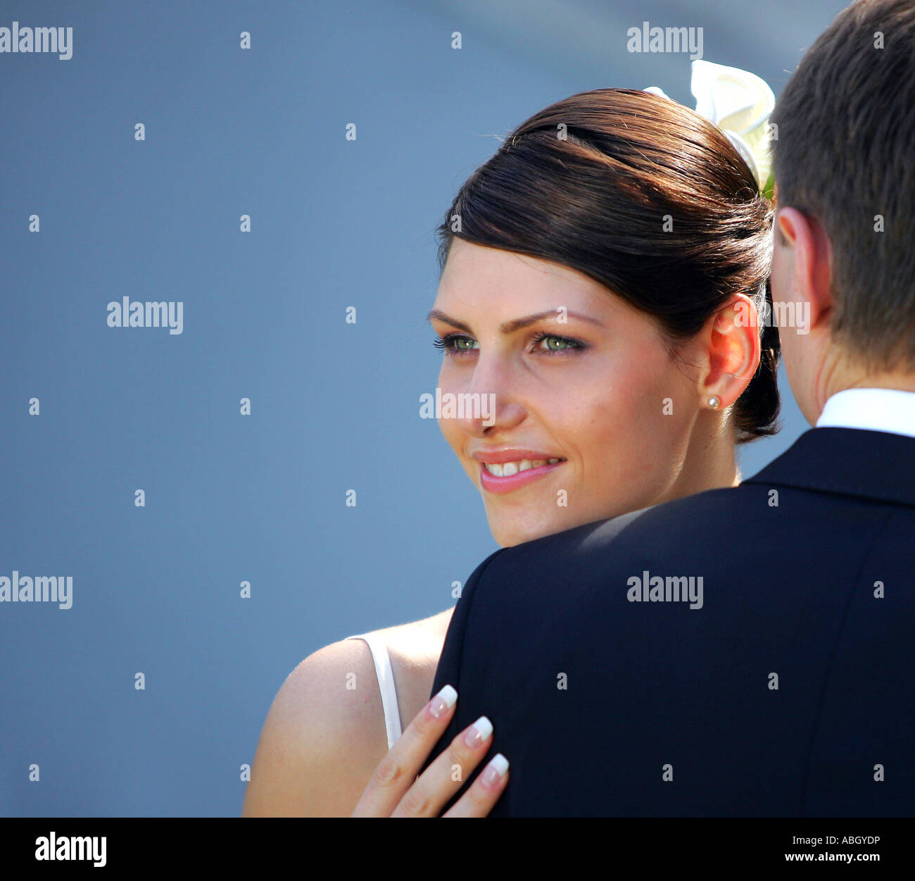 Eine Braut in eine traditionelle weiße Hochzeit Kleid gesehen hier auf der Suche über die Schulter neue Ehemänner. Stockfoto