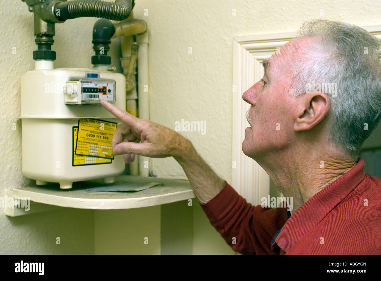 71 Jahre alten älterer Mann lesen Gaszähler zu Hause, Hounslow, West London, UK. Dieses Bild ist Modell freigegeben (MR). Stockfoto