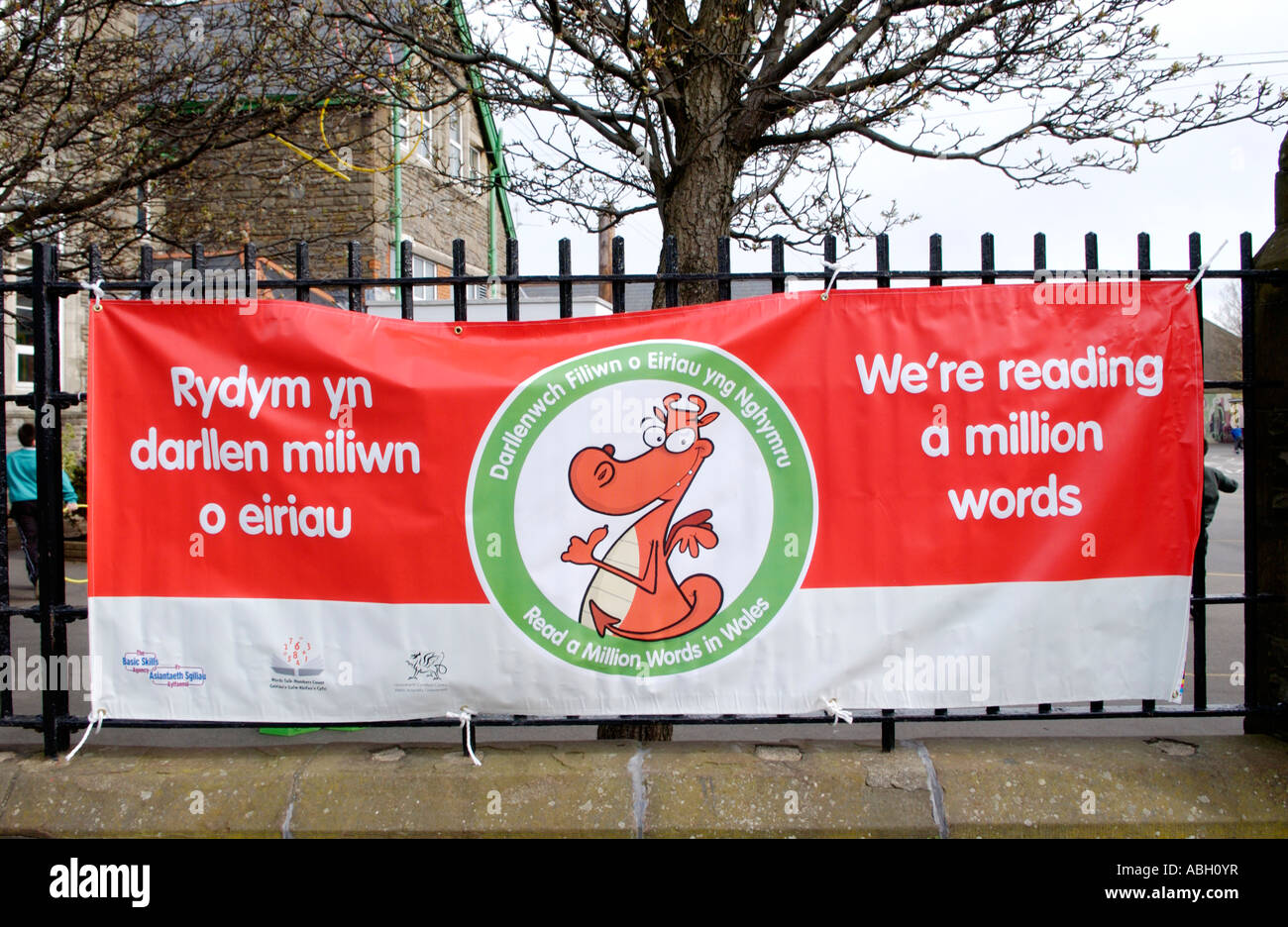 Zweisprachige Lesung Projekt Banner hängen am Zaun außerhalb Cardiff Grundschule South Wales UK Stockfoto