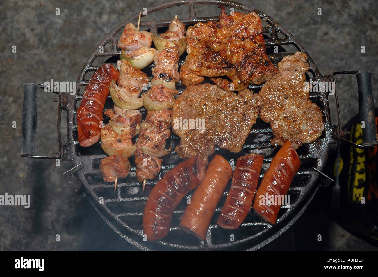 Würstchen, Fischspieße, chuck Steak auf dem Grill Stockfoto
