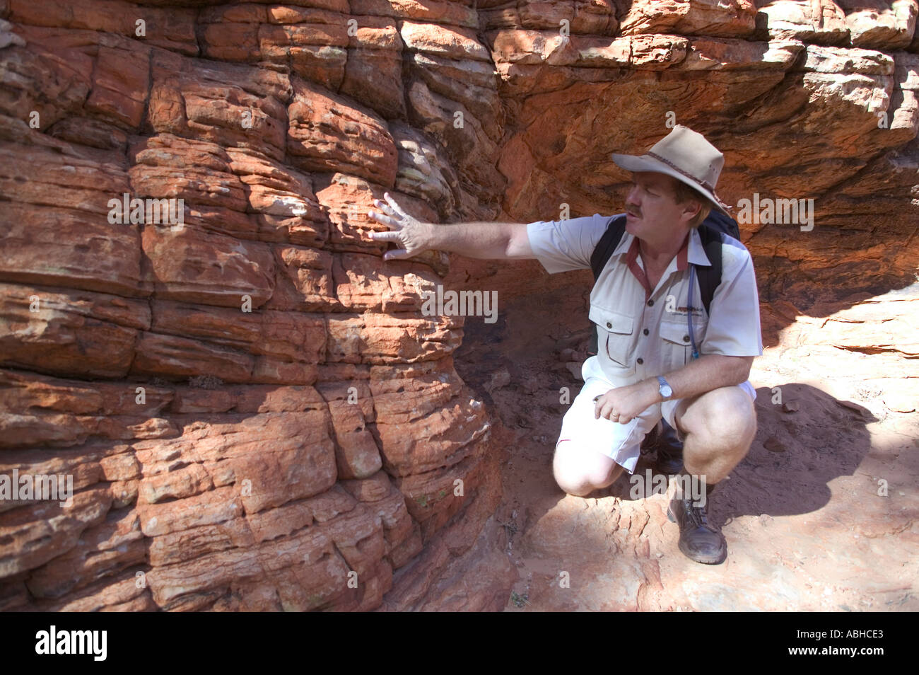 Tourguide erklärt komplexe geologische Prozesse, die zur Bildung von Kings Canyon im Northern Territory von Australien geführt Stockfoto