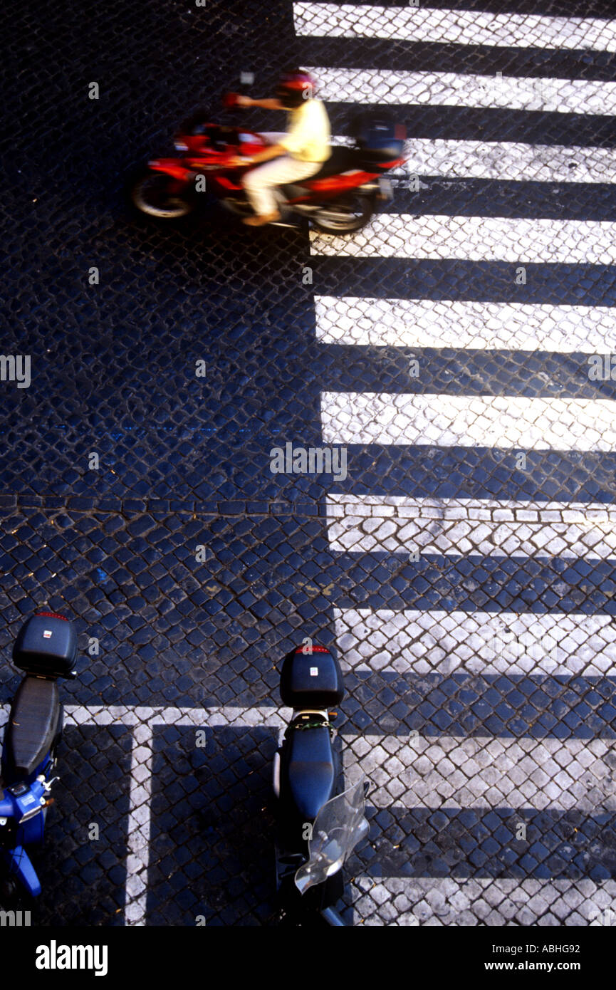 Roten Motorrad überquert Fußgänger-Zebrastreifen mit geparkten Rollern in der Nähe von Hauptbahnhof in Rom-Latium-Italien Stockfoto