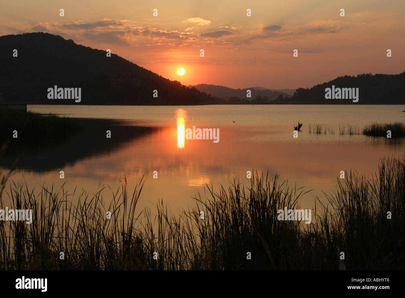 Sonnenuntergang über einem See in Thailand Stockfoto