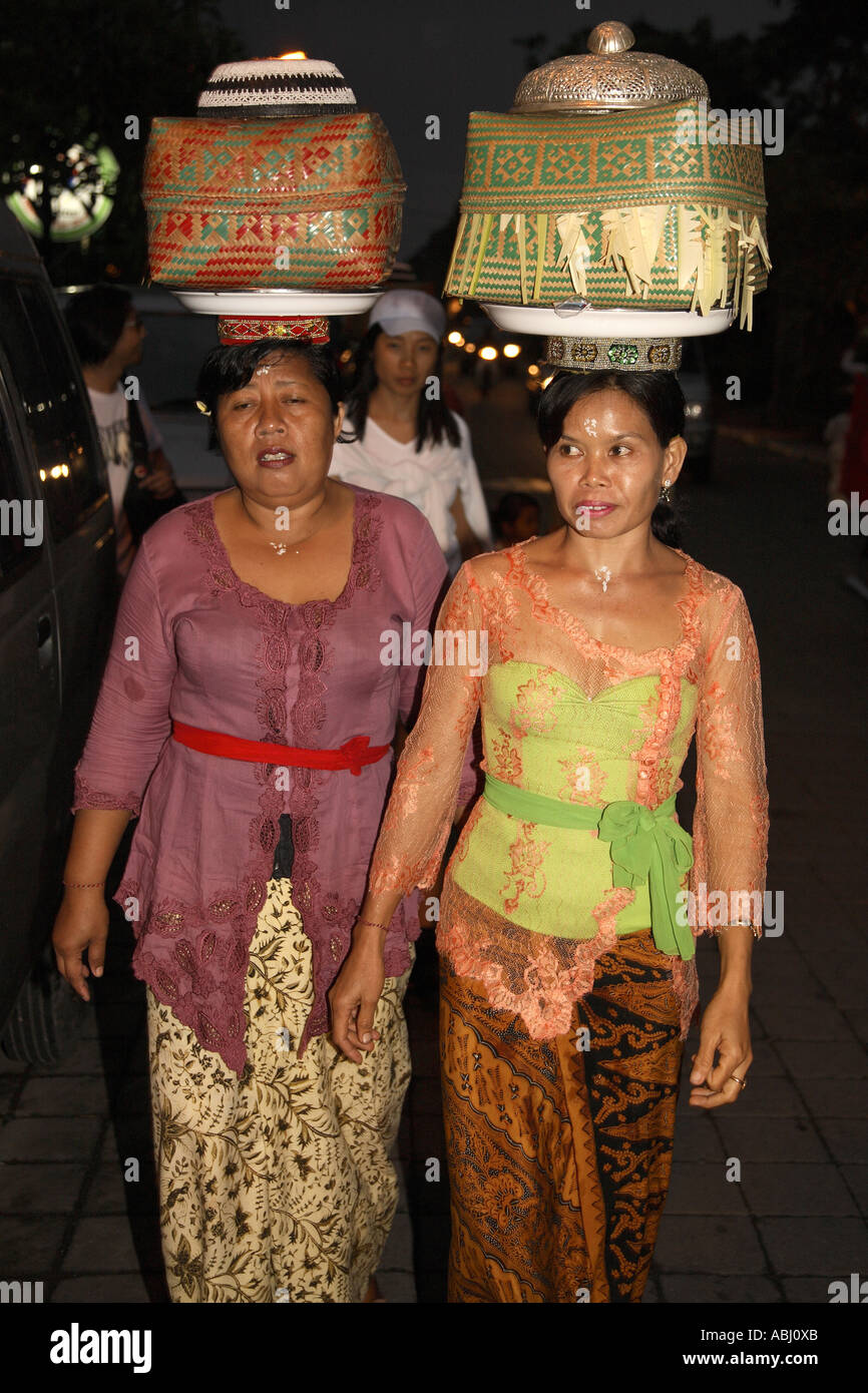 Balinesischen Frauen, die die Opfergaben in den Tempel bei Nacht, Ubud, Bali, Indonesien Stockfoto