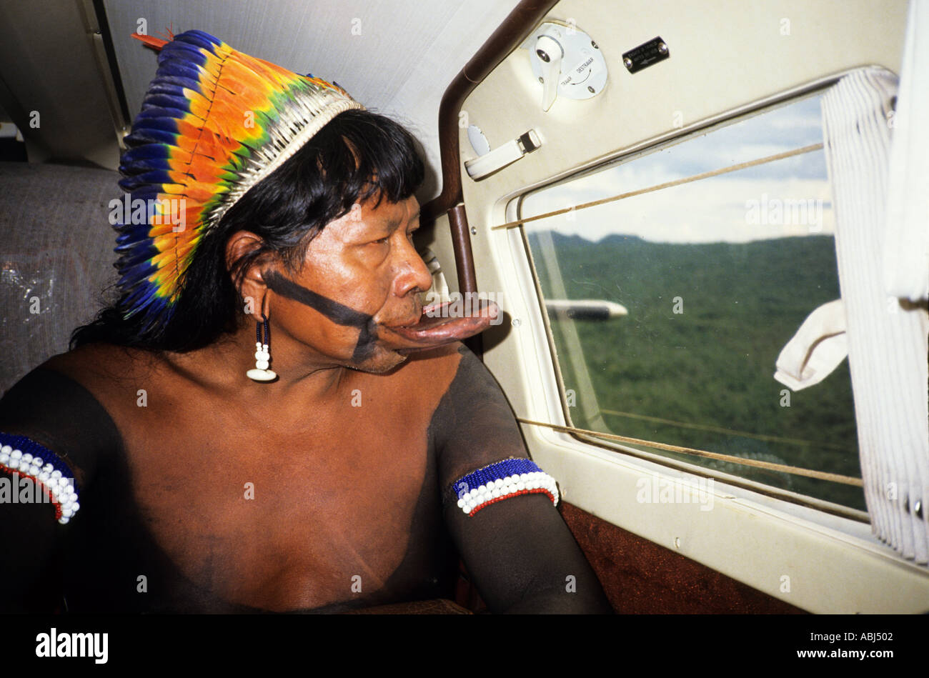 Amazonas, Brasilien. Chief Raoni von Megranoti (Kayapo Nation) mit Botoque und Feder Cocar Kopfschmuck in einem Flugzeug. Stockfoto