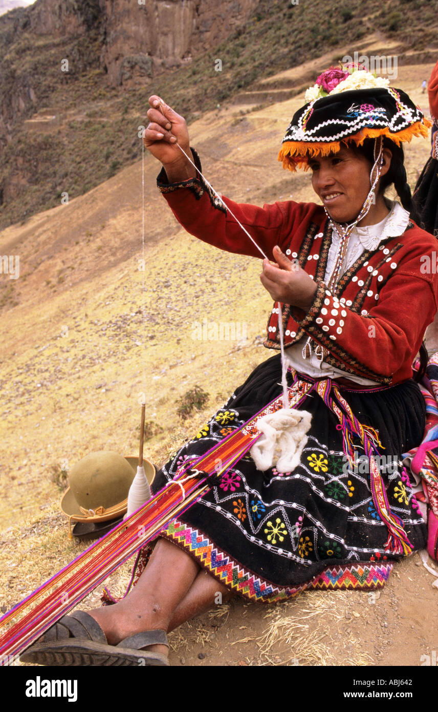Pisac, Peru. Quechua indische Frau in traditioneller Kleidung ein Armband Weben und Spinnen. Stockfoto