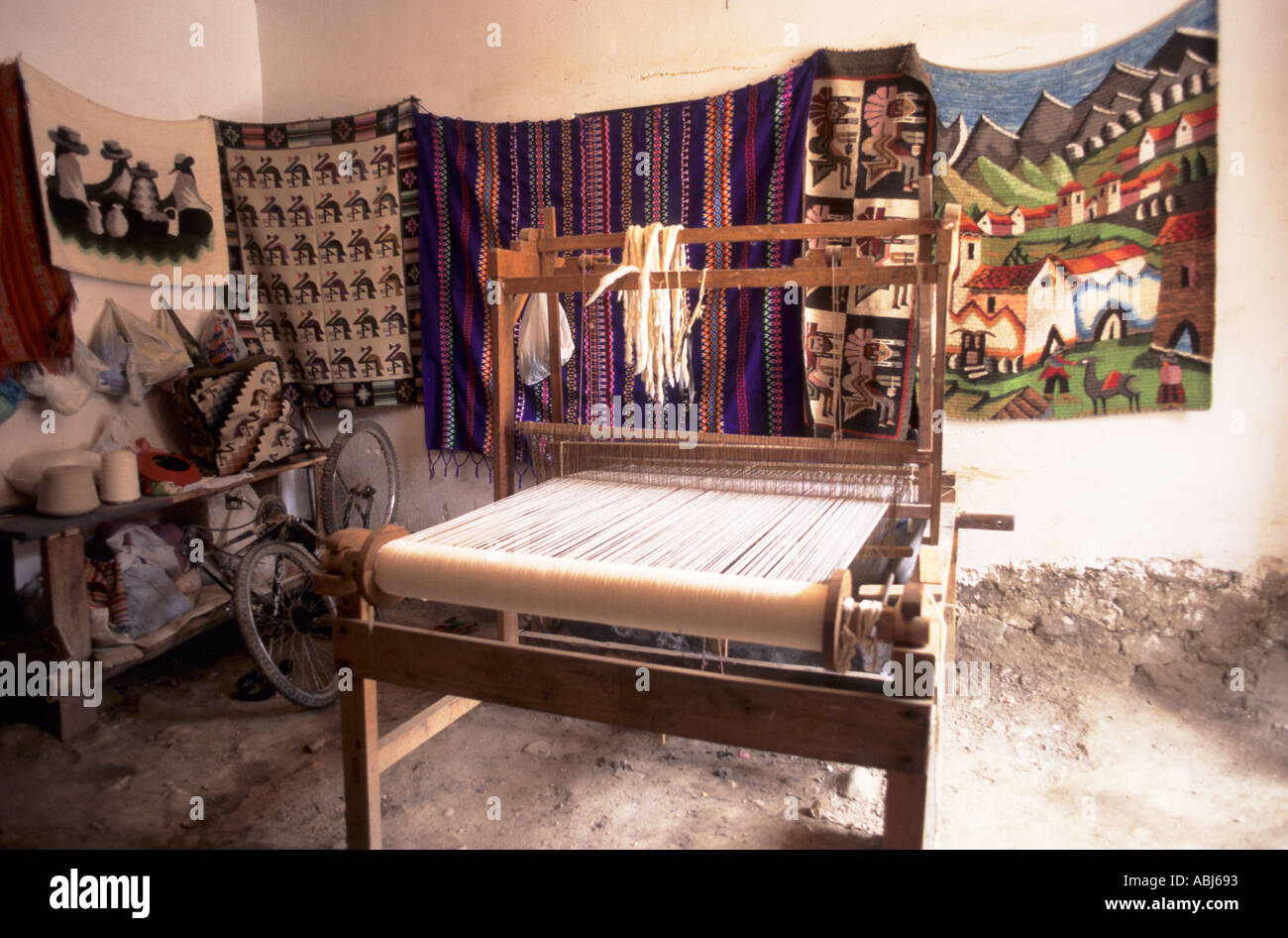 Ollantaytambo, Peru. Kleiner Webstuhl und gewebten Produkten seitens der Weber an den Wänden hängen. Stockfoto