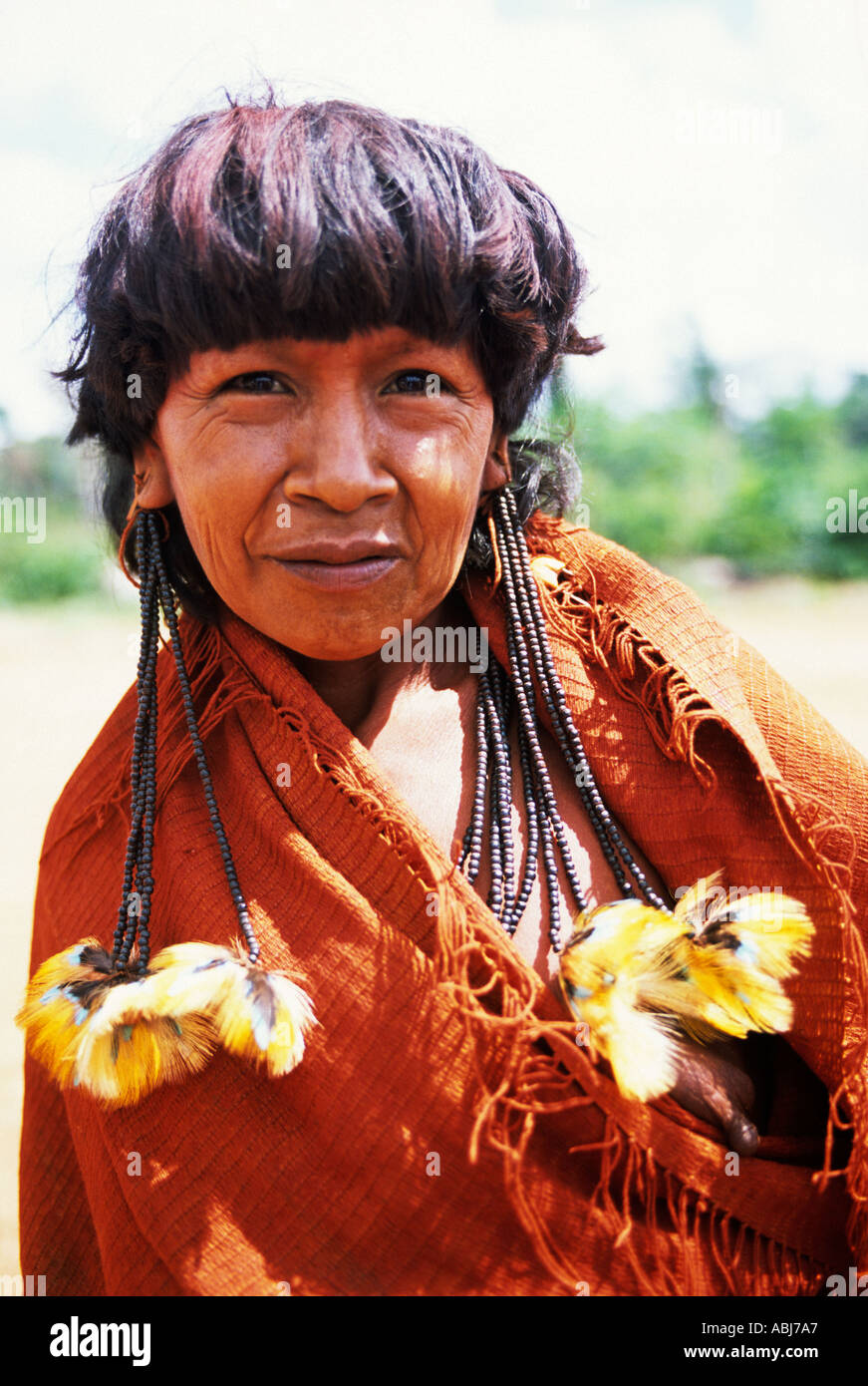 Ipixuna Dorf, Bundesstaat Para, Brasilien. Arawete indische Frau in rot Wrap Schal mit Federn und Perlen Haarschmuck. Stockfoto
