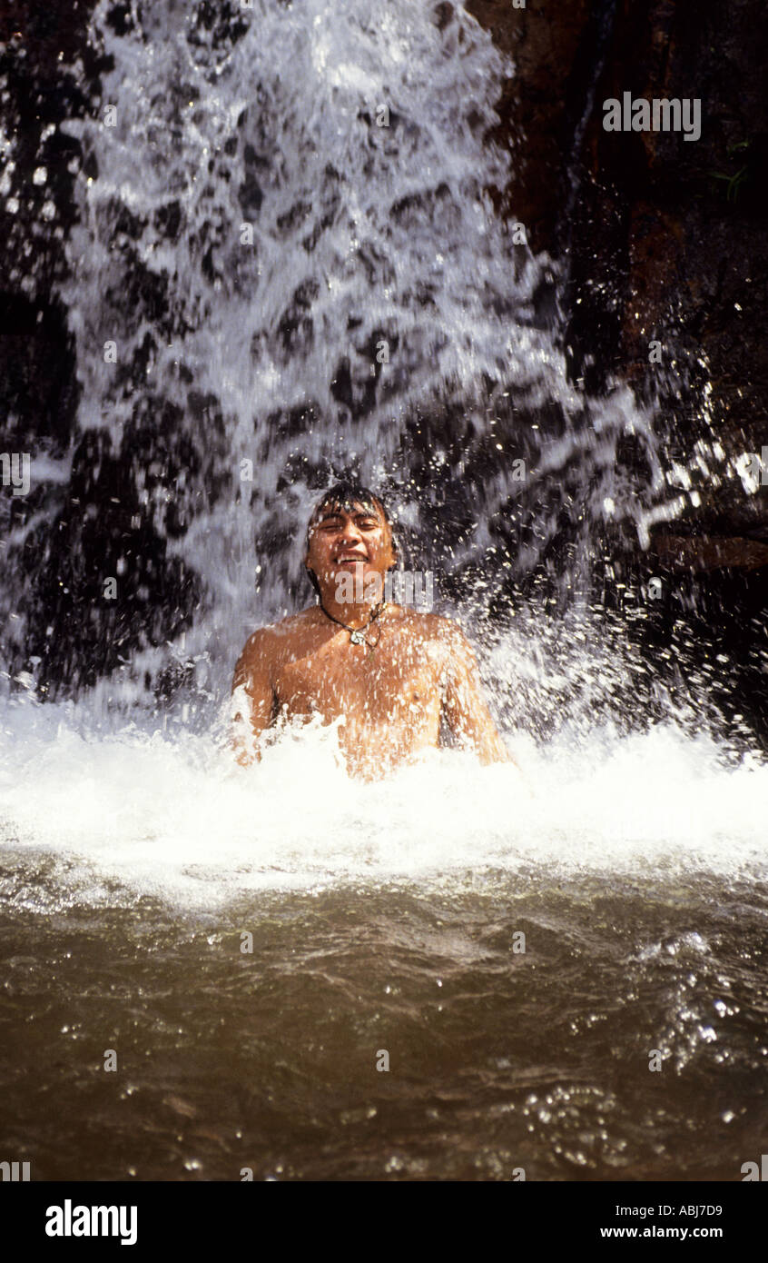 Bundesstaat Roraima, Brasilien. Ein junger Yanomami Indianer Mann genießen das Baden im Wasserfall. Stockfoto