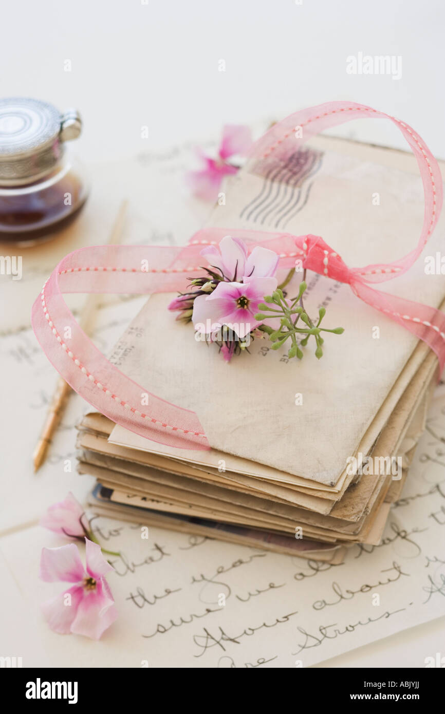Stapeln von alten Buchstaben neben Blumen und Tintenfass Stockfoto